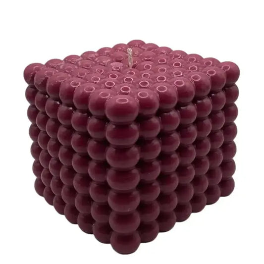 Maroon cube-shaped large pillar candle with a textured surface on a white background