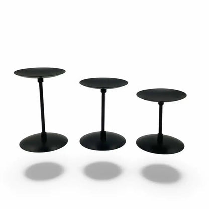 Three piece matte black wrought iron candle stands with varying heights, adding modern minimalist elegance to any decor.