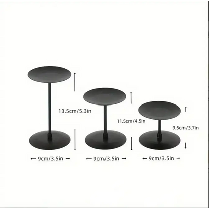 Three piece matte black wrought iron candle stands in varying heights.