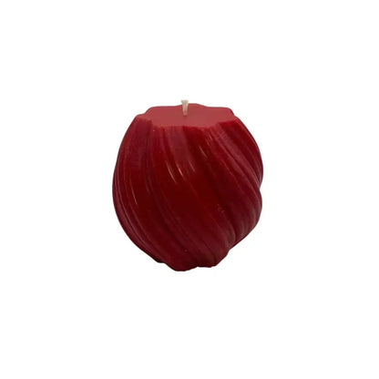 A red Vanilla and Cinnamon Scented Soy Pillar candle resembling a ball with textured curves on a white background
