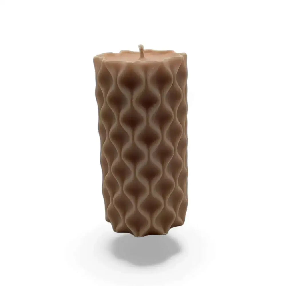 Vanilla scented soy wavy pillar candle with artistic texture.